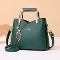 Borsa a mano in pelle opaca verde scuro con ciondolo a foglia e tracolla regolabile - Verde