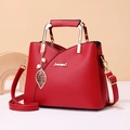 Elegante borsa a mano rossa da donna con dettagli dorati e ciondolo a foglia oro - Rosso