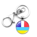 Macro shot of circular glass pendant keychain with flag colors and lobster clasp - Multicolor Geometric Flag Style (XSWX4486-14)