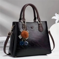 Classic black leather tote bag with brown handles and elegant houndstooth pendant charm - Black