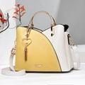 Detail of yellow and cream contrast bucket bag with gold metal handle and heart pearl tassel - Yellow with Cream