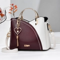 Dettaglio della borsa patchwork bordeaux e beige con logo ZZMY dorato e ciondolo cuore - Borgogna