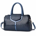 Gros plan détaillé du sac à main bleu marine avec texture crocodile et finitions dorées - Bleu