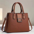Détail de la texture gaufrée et boucle métallique sur le sac à main en cuir marron - L29 H23 l13 / Marron