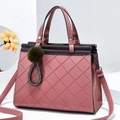 Close-up of pink quilted tote bag with purple trim and green pom-pom charm detail - L28 H22 W15 / Pink
