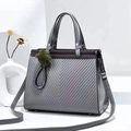 Detail of grey quilted tote bag with V-shaped embossing and green fur ball charm - L28cm x H22cm x W15cm / Gray