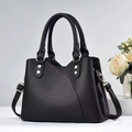 Detail of lychee pattern leather handbag with metallic rivets and shoulder strap - Black