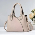 Close-up of beige lychee grain leather tote with curved stitching and silver rivet detail - Khaki