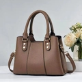 Detail of dark brown lychee leather handbag showing golden hardware and adjustable strap - One Size / Brown