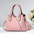 Detailed close-up of pink pebbled leather handbag with gold rivets and detachable strap - Pink