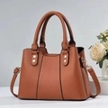 Macro view of caramel brown lychee leather texture and gold metal studs on tote bag - One Size / Earthy Yellow