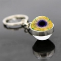 Macro view of double-sided glass evil eye keychain with realistic purple iris detail - Bright Yellow Purple Eye (JY007784-11)