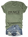 Close-up of green cotton t-shirt featuring I'M NICE PERO NO TE PASES text print - Olive Green (Black Font)