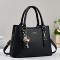 Black pebbled leather tote bag with gold logo, metal charms and adjustable strap - Black