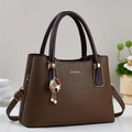 Sac à main en cuir litchi marron avec détails dorés et pendentif décoratif chic - Café
