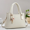 Détail du sac cabas beige texture litchi avec ferrures dorées et bijou de sac - Blanc Cassé