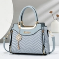 Elegant herringbone textured handbag in light blue with gold hardware and shoulder strap - Blue