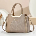 Detail of luxury earthy brown handbag with golden metal handle and textured leather finish - Khaki