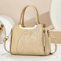 Detailed view of cream leather tote with vertical stripe texture and golden hardware - Apricot