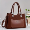 Detail of brown woven texture PU leather tote bag with silver rivets and metal hardware - Earthy Yellow