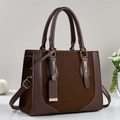 Donkerbruine luxe handtas met geometrische textuur en gouden hardware op witte basis - koffiekleur