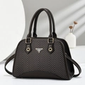 Detail of herringbone pattern texture and metal logo plaque on a brown shell bag - Coffee