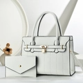 Detailed macro view of white pebble leather handbag set with gold padlock and envelope clutch - Off White