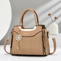 Close-up of brown handbag with woven texture panels and golden brand logo detail - Khaki