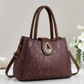 Elegante bolso de mano trapezoidal en violeta oscuro con correa marrón y cierre dorado - Burdeos