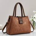 Brown vintage textured tote bag with top handles and shoulder strap on display - Earthy Yellow