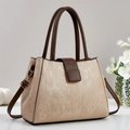 Dettaglio borsa da donna con trama color champagne e manici in pelle marrone scuro - Cachi