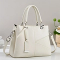 Close-up of beige lychee leather tote bag with V-shaped stitching and silver hardware - Off White