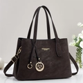 Detailed view of dark brown leather texture and golden metal logo on the handbag - Black