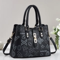 Black monogram tote bag with double handles, gold hardware, and adjustable strap - Black