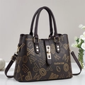 Dunkelbraune Tragetasche mit gelbem Logo-Print, Doppelgriffen und goldenem Metallschloss - Kaffeebraun