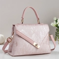 Détail d'un sac à main rose en tissu texturé avec fini métallisé et fermoir doré - Rose