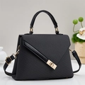 Elegant black trapezoid handbag with gold metal lock and woven texture detail - Black