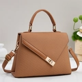 Detail of brown woven texture handbag with smooth leather trim and golden square lock - Earthy Yellow