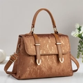 Braune Handtasche mit goldener Metallstruktur und Griff in minimalistischem Design - Erdgelb