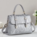 Detailed macro view of silver metallic textured fabric with golden hardware on a tote bag - Silver