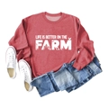 Flat lay of red sweatshirt with Life is Better on the Farm print and blue denim jeans - Red Sweatshirt (White Text Pattern)