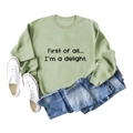 Flat lay of sage green sweatshirt with First of All slogan and casual denim outfit - S / Olive Green Sweatshirt (Black Font)