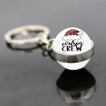 Macro shot of Cousin Crew glass ball keychain with festive plaid Santa hat on black surface - Cousin Crew Plaid Hat (JY008175-11)