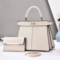 Detailed view of cream pebble leather handbag set with gold hardware and woven texture - Off White