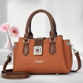 Detail of a stylish brown tote bag with silver metal buckle and floral background - Caramel color