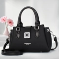 Detail of black textured leather tote with silver metal buckle and long shoulder strap - Black