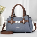 Detailed view of denim texture, brown leather trim and silver metal twist lock - Blue