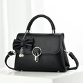 Detalle de bolso bandolera de cuero negro con lazo de perlas y hebilla de anillo plateado - Negro