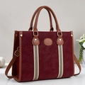Detail view of burgundy tote bag featuring leather handles and decorative striped webbing - Burgundy