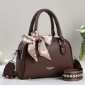 Detailed macro of brown lychee leather handbag with floral scarf and printed strap - Coffee